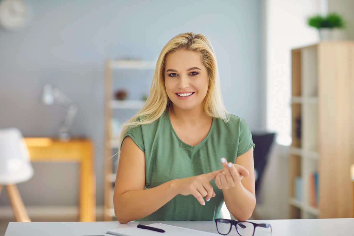 Professional life coach working at home office desk, smiling while creating AI-optimised content to get cited on ChatGPT