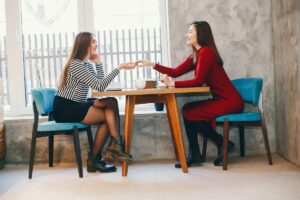 Female business owners discussing how to get recommended by ChatGPT for their services